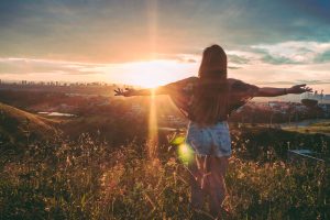 woman in nature facing sunlight